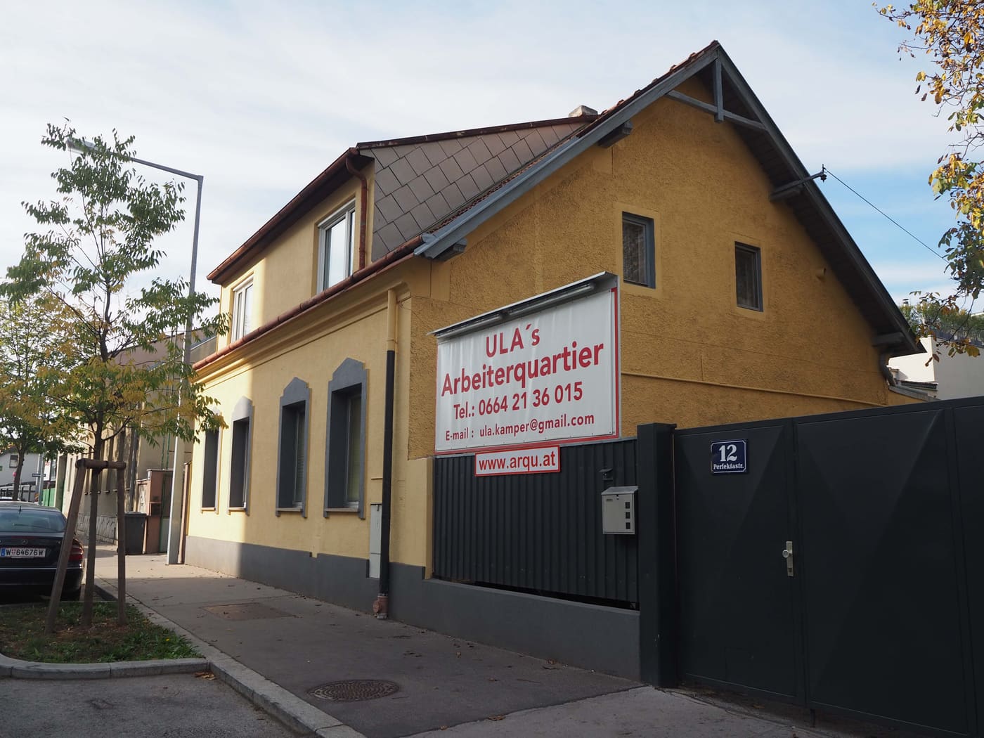 Das gelbe Haus in der Perfektastraße 12 mit dem Schild „ULA’s Arbeiterquartier“